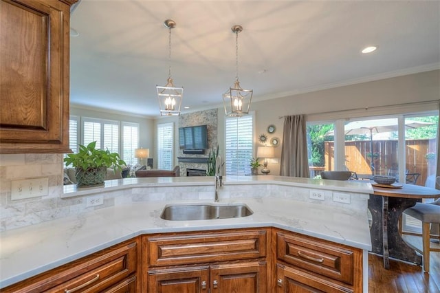 16141 Linden St, Stilwell, KS 66085 - kitchen featuring a sink, brown cabinets, healthy amount of natural light, pendant lighting, and crown molding