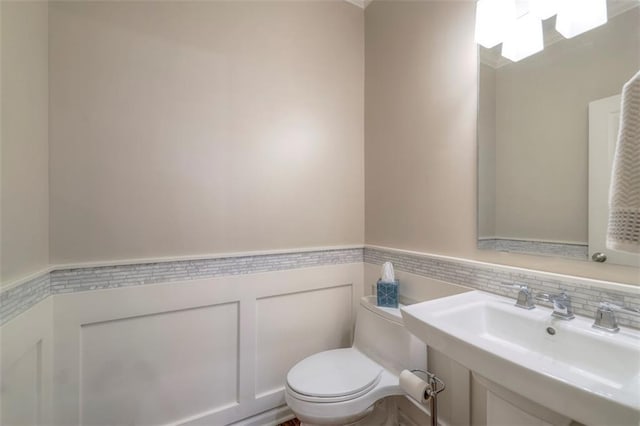 16141 Linden St, Stilwell, KS 66085 - bathroom featuring a wainscoted wall, toilet, and a sink
