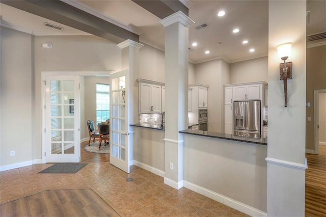 16141 Linden St, Stilwell, KS 66085 - kitchen featuring appliances with stainless steel finishes, crown molding, ornate columns, baseboards, and french doors