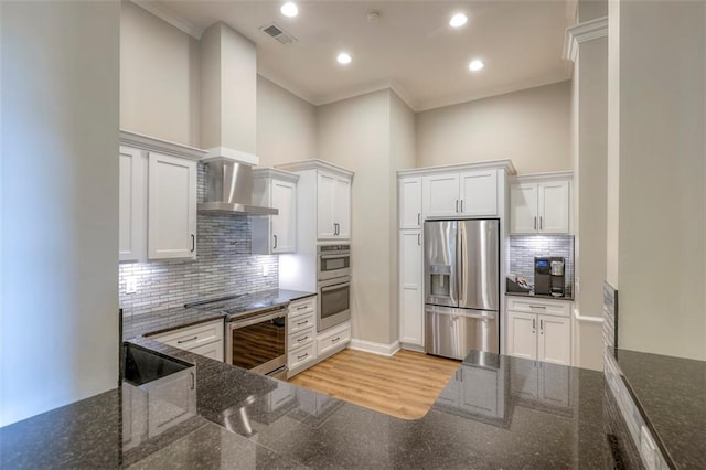 16141 Linden St, Stilwell, KS 66085 - kitchen featuring appliances with stainless steel finishes, wall chimney exhaust hood, crown molding, white cabinetry, and decorative backsplash