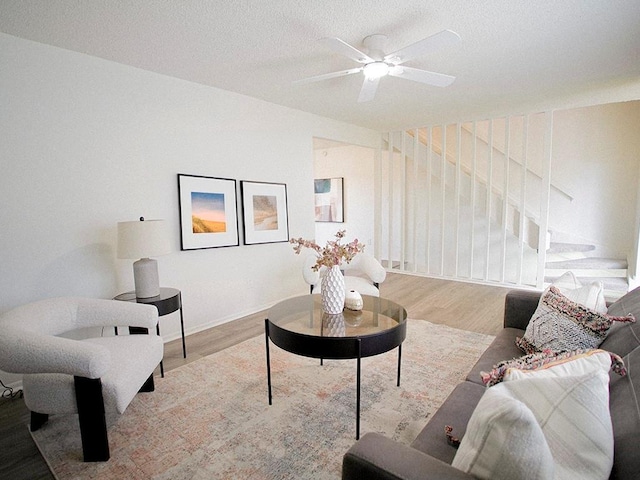 10921 Mckinley Dr, Kansas City, MO 64134 - living room featuring wood finished floors, ceiling fan, stairway, and a textured ceiling