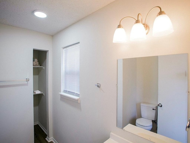 10921 Mckinley Dr, Kansas City, MO 64134 - bathroom with toilet, a textured ceiling, and baseboards