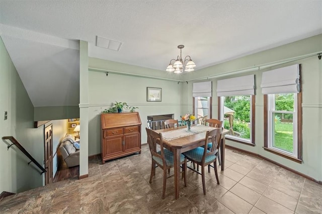dining area with a chandelier, a textured ceiling, and baseboards