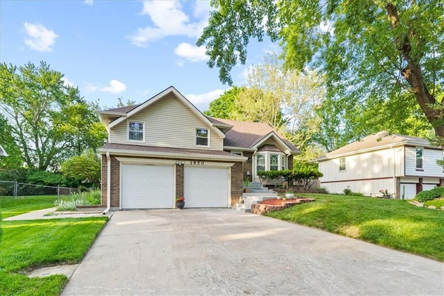 split level home featuring a garage, driveway, a front lawn, and brick siding