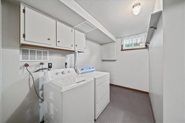 washroom with cabinet space, washing machine and dryer, and baseboards
