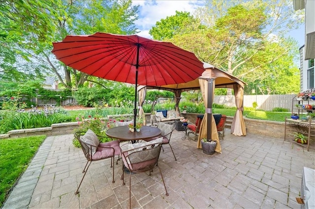 view of patio / terrace featuring a gazebo, outdoor dining area, and a fenced backyard
