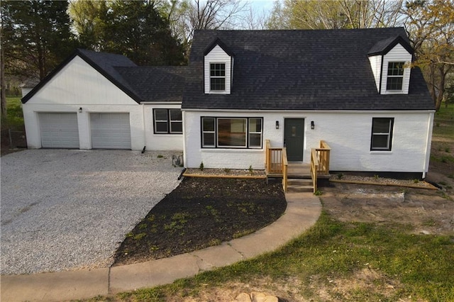 10514 E 35th St S, Independence, MO 64052 - cape cod-style house featuring gravel driveway, an attached garage, a shingled roof, and brick siding