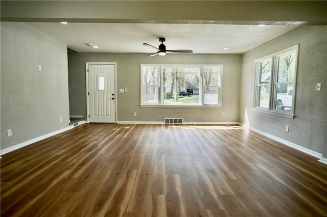 10514 E 35th St S, Independence, MO 64052 - unfurnished living room with dark wood-style floors, ceiling fan, baseboards, and a textured wall