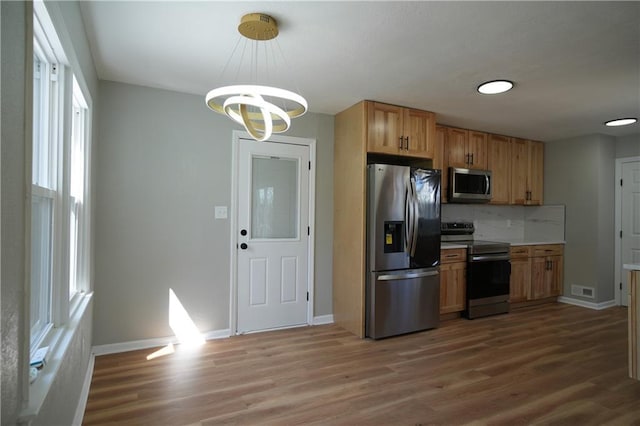 10514 E 35th St S, Independence, MO 64052 - kitchen with appliances with stainless steel finishes, light wood-style flooring, decorative backsplash, and baseboards
