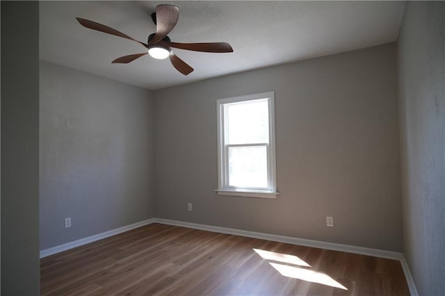 10514 E 35th St S, Independence, MO 64052 - unfurnished room with wood finished floors, a ceiling fan, and baseboards
