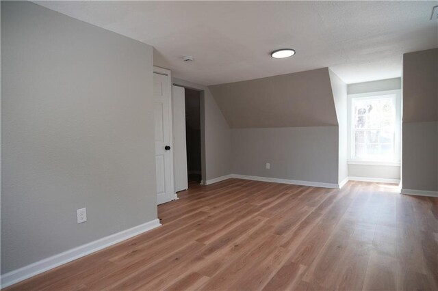 10514 E 35th St S, Independence, MO 64052 - bonus room featuring baseboards, light wood-style floors, and vaulted ceiling
