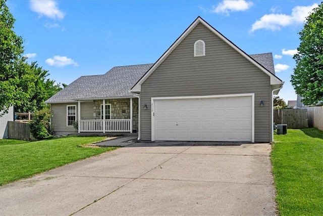 traditional home with covered porch, an attached garage, concrete driveway, cooling unit, and a shingled roof
