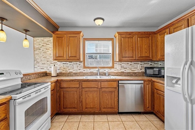 kitchen featuring white appliances, a sink, tasteful backsplash, and brown cabinetry