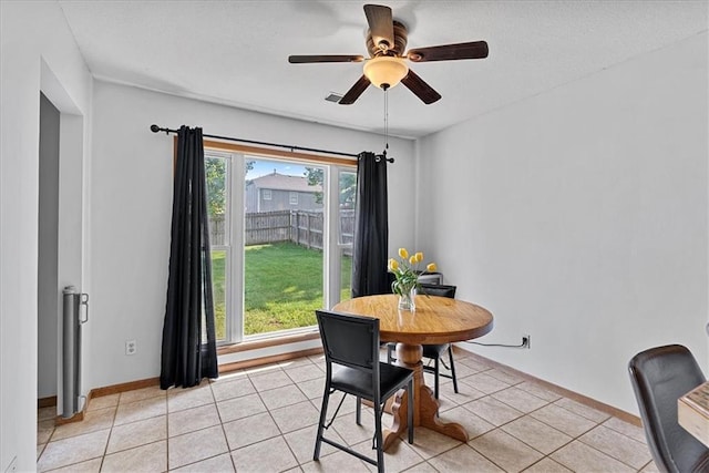 dining area featuring ceiling fan, baseboards, and light tile patterned flooring