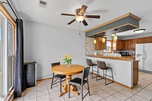 dining space featuring a ceiling fan and light tile patterned flooring