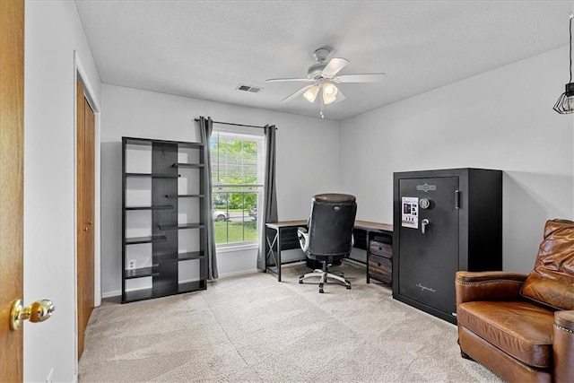 carpeted home office with a ceiling fan, baseboards, and a textured ceiling