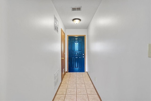entryway with light tile patterned floors and baseboards