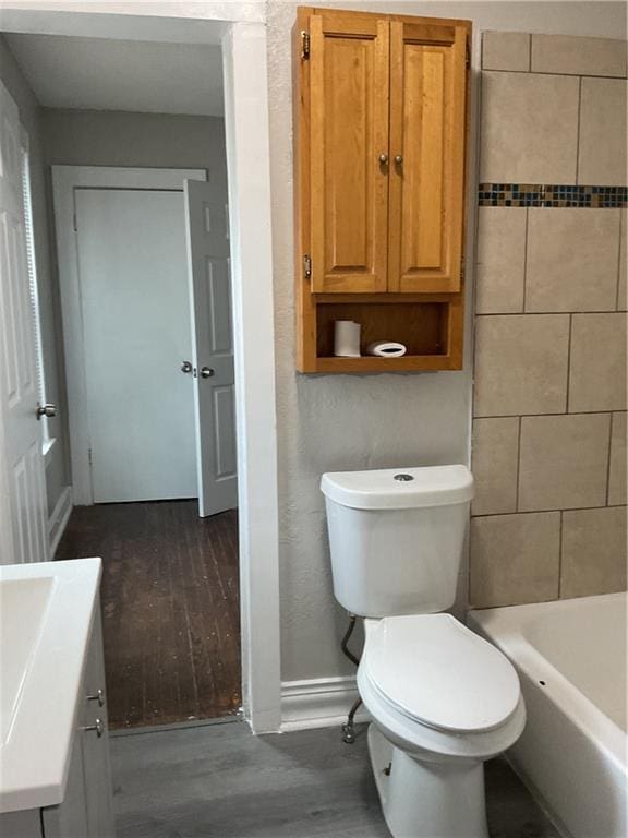 3624 Mersington Ave, Kansas City, MO 64128 - full bath featuring a bathtub, toilet, baseboards, wood finished floors, and a shower