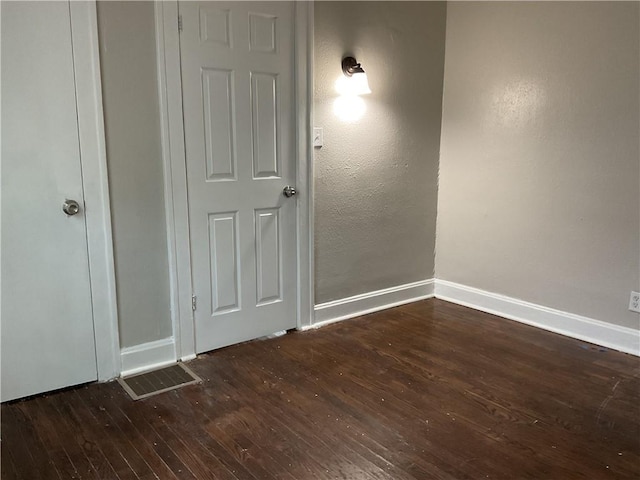 3624 Mersington Ave, Kansas City, MO 64128 - empty room with dark wood-type flooring and baseboards