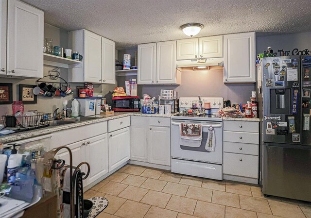 817 S Hardy Ave, Independence, MO 64053 - kitchen with fridge with ice dispenser, white range with electric stovetop, under cabinet range hood, open shelves, and white cabinetry