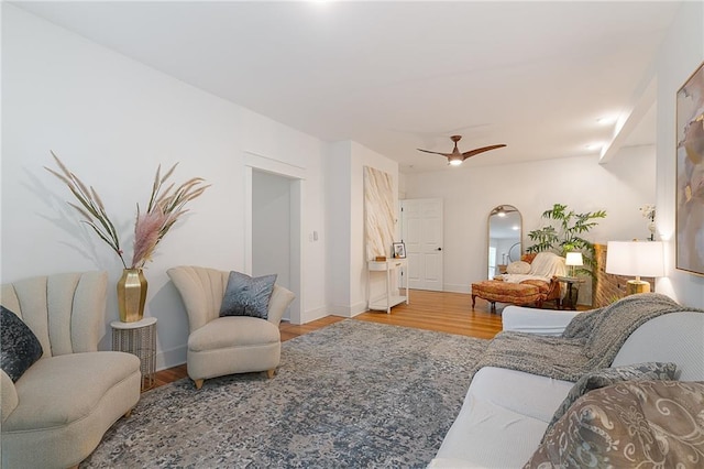 living room featuring wood finished floors, ceiling fan, and baseboards