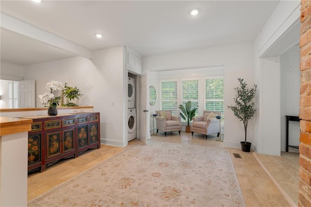 sitting room with stacked washer / dryer and recessed lighting