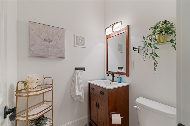 bathroom with vanity, toilet, and baseboards