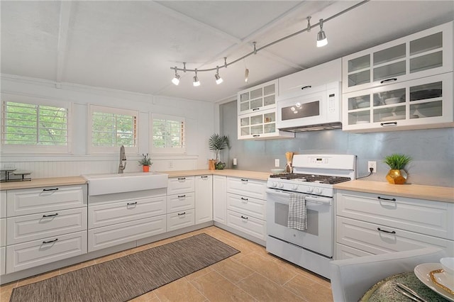 kitchen featuring white appliances, a sink, plenty of natural light, and white cabinets