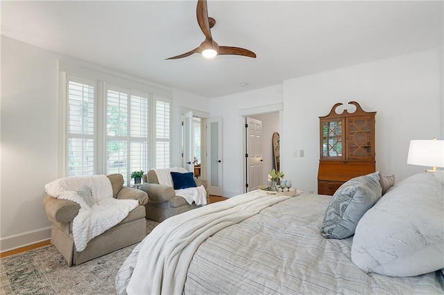 bedroom featuring wood finished floors, baseboards, and a ceiling fan