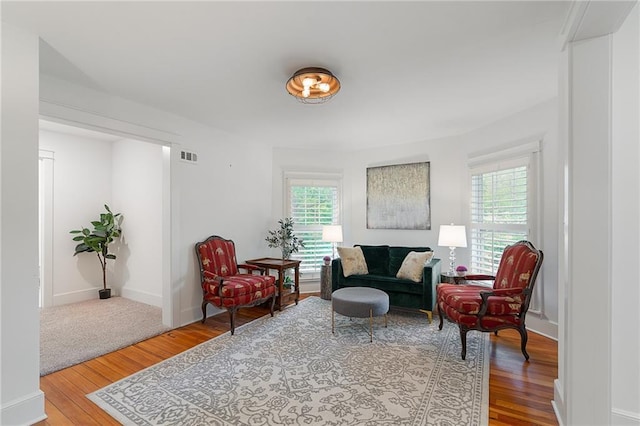 sitting room with healthy amount of natural light, wood finished floors, and baseboards