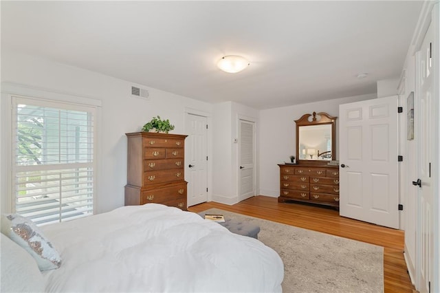 bedroom featuring light wood finished floors and baseboards
