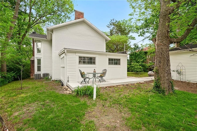 back of property with a patio, a chimney, and a yard