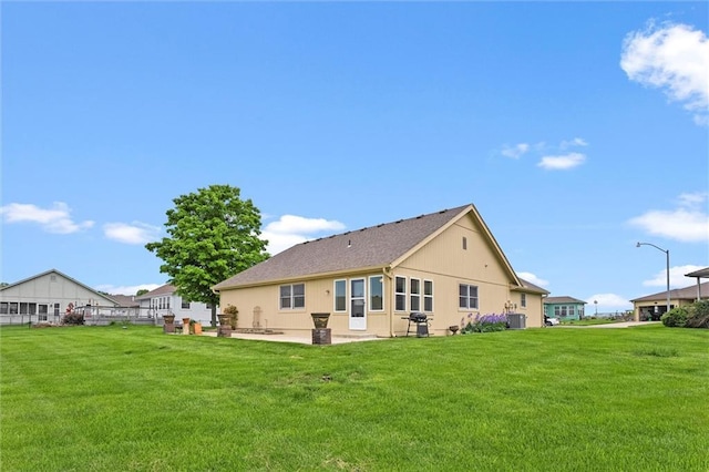 721 Cupid Ct, Raymore, MO 64083 - back of house with a yard, a patio, and central AC unit
