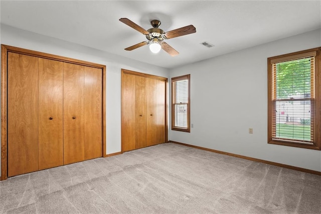721 Cupid Ct, Raymore, MO 64083 - unfurnished bedroom featuring multiple closets, multiple windows, and light carpet