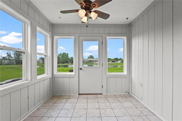 721 Cupid Ct, Raymore, MO 64083 - unfurnished sunroom with a water view, healthy amount of natural light, tile patterned flooring, and wooden walls