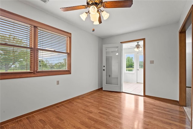 721 Cupid Ct, Raymore, MO 64083 - spare room with light wood-type flooring, a ceiling fan, and baseboards