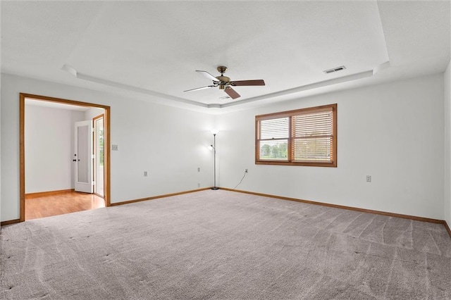 721 Cupid Ct, Raymore, MO 64083 - spare room with a raised ceiling, carpet floors, a ceiling fan, and baseboards