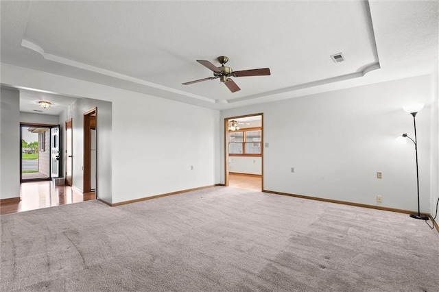 721 Cupid Ct, Raymore, MO 64083 - carpeted empty room featuring a tray ceiling, a ceiling fan, and baseboards