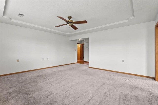 721 Cupid Ct, Raymore, MO 64083 - empty room featuring a tray ceiling, a ceiling fan, light colored carpet, and baseboards