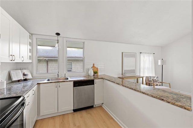 kitchen featuring dishwasher, a sink, light wood finished floors, white cabinets, and light stone counters