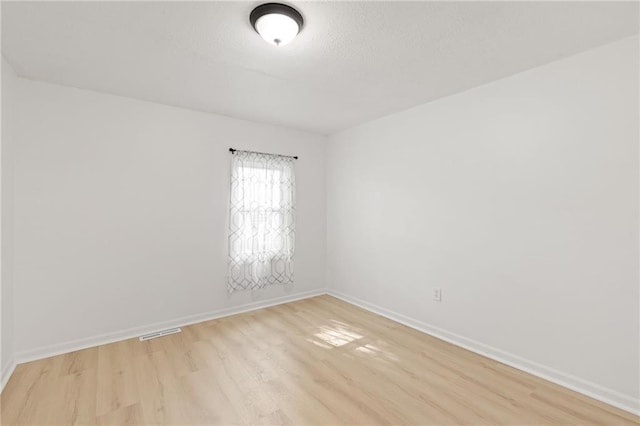 unfurnished room featuring light wood-type flooring and baseboards