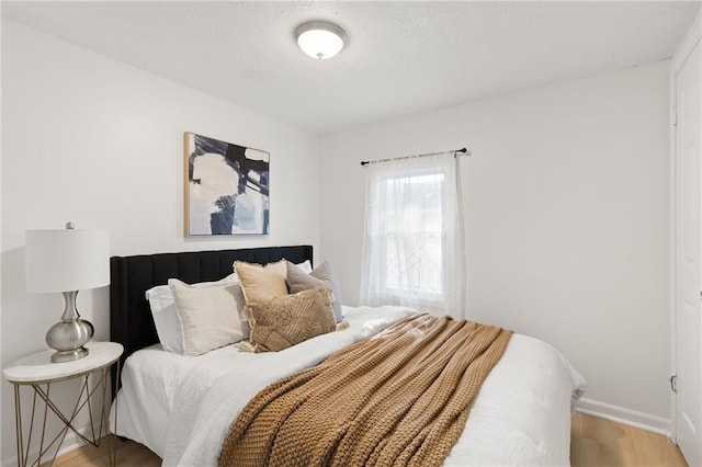 bedroom with light wood-style floors and baseboards