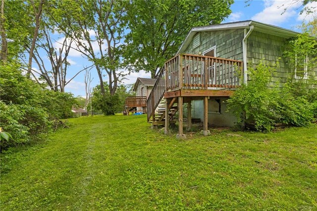 view of grassy yard with a wooden deck and stairs