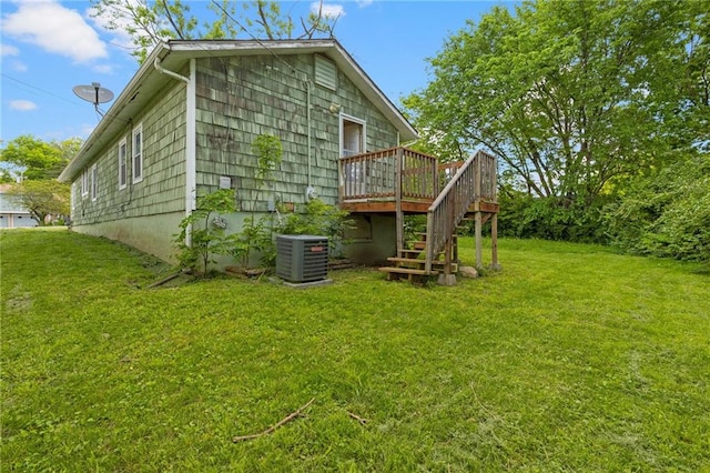 rear view of property with stairs, a wooden deck, central AC unit, and a lawn