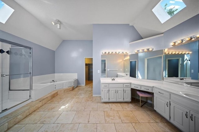 bathroom featuring a skylight, lofted ceiling, a stall shower, double vanity, and a garden tub