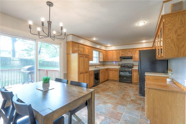 5805 N Belton Ave, Kansas City, MO 64151 - kitchen with black appliances, under cabinet range hood, a chandelier, glass insert cabinets, and light stone finish flooring