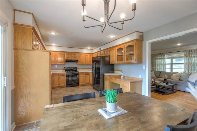 5805 N Belton Ave, Kansas City, MO 64151 - kitchen featuring black appliances, under cabinet range hood, glass insert cabinets, a chandelier, and light countertops