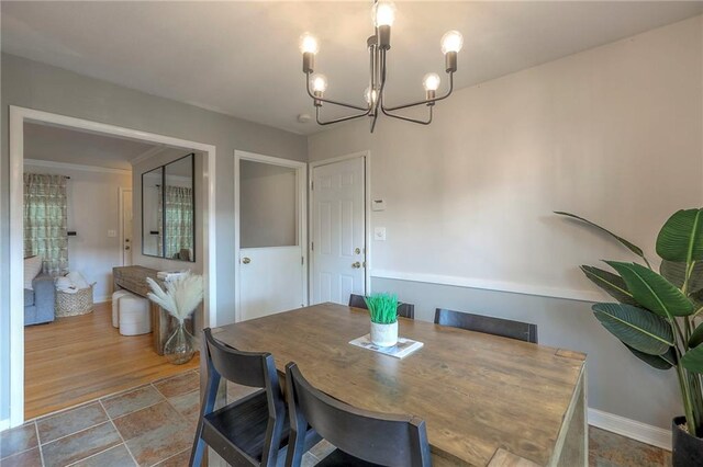 5805 N Belton Ave, Kansas City, MO 64151 - dining room with a chandelier, baseboards, and stone finish floors
