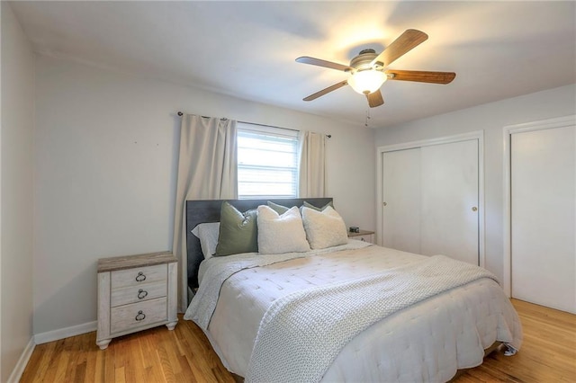 5805 N Belton Ave, Kansas City, MO 64151 - bedroom with light wood-style flooring, ceiling fan, two closets, and baseboards