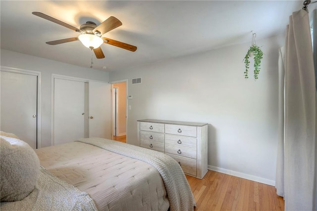 5805 N Belton Ave, Kansas City, MO 64151 - bedroom featuring light wood finished floors, baseboards, multiple closets, and ceiling fan